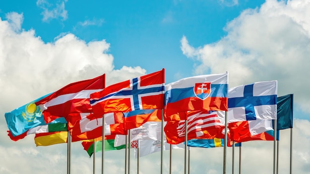 깃발 많은 밝은 깃발이 바람에 하늘을 향해 발전합니다. 덴마크 라트비아 핀란드 및 기타