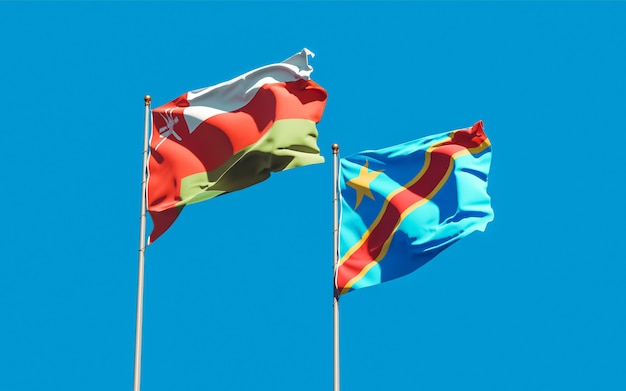 Flags of Oman and DR Congo on blue sky. 3D artwork