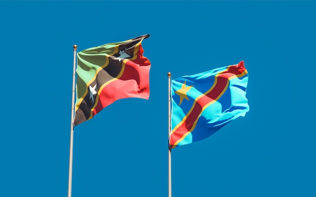 Flags of Saint Kitts and Nevis and DR Congo on blue sky. 3D artwork