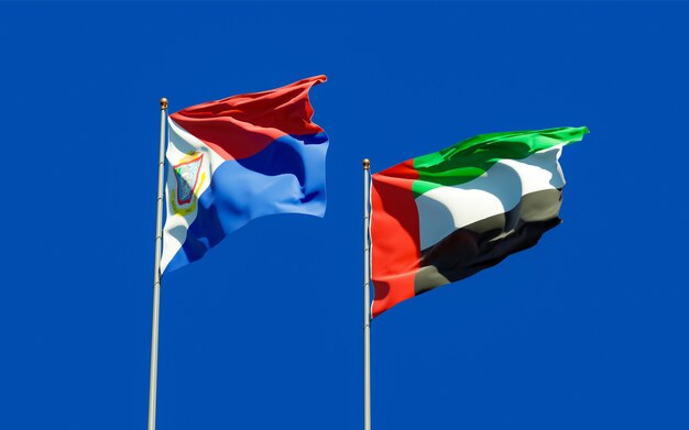 Flags of Sint Maarten and UAE Arab Emirates on blue sky. 3D artwork