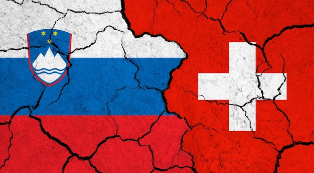 ひび割れた表面の政治関係概念上のスロベニアとスイスの国旗