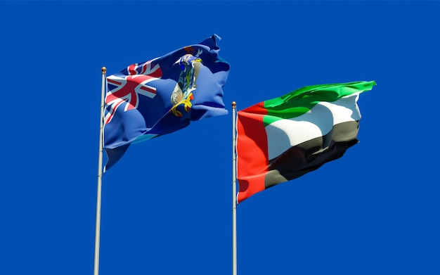 Flags of South Georgia and the South Sandwich Islands and UAE Arab Emirates on blue sky. 3D artwork
