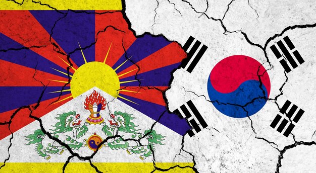 Photo flags of tibet and south korea on cracked surface politics relationship concept