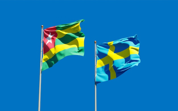 Flags of Togo and Sweden on blue sky. 3D artwork