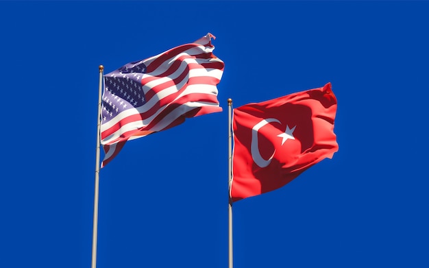 Flags of Turkey and USA on sky background