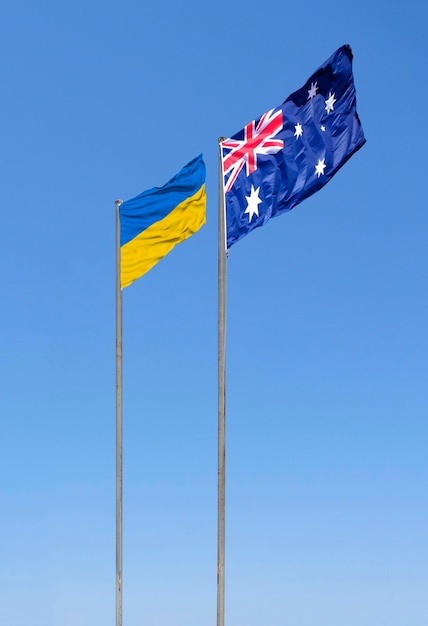 Flags of Ukraine and the UK are flying against the blue sky