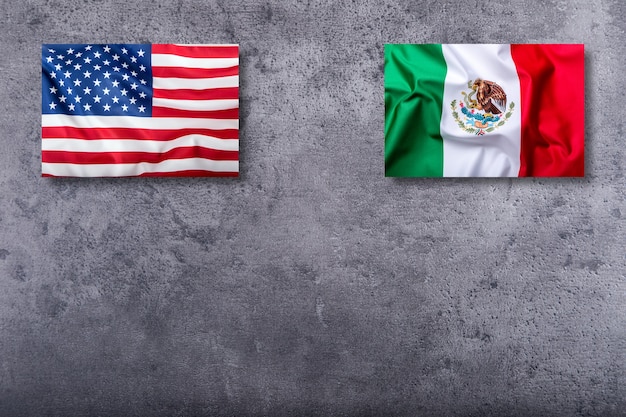 Flags of the USA and mexico on concrete background.