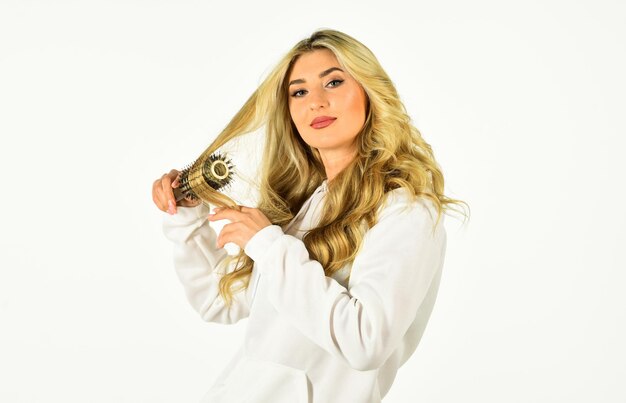 Flair for Hair. fashion model woman. Beautiful blonde woman. Girl With Gorgeous Healthy Smooth Hair Using hairbrush For Perfect Curls. Girl care of hairstyle. Fashion and beauty. Stylist curling hair.