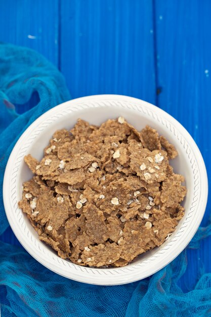 Flakes in white bowl on blue wooden