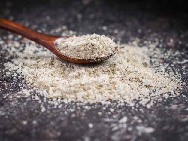 Flaky sea salt with herbs scattered on the stone table