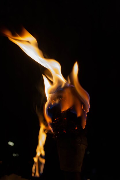 Foto fiamma di una torcia fatta in casa in una notte buia su uno sfondo di neve