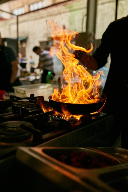 flame in the pan Professional Chef makes flambe for food in the restaurant kitchen