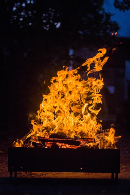 Fiamma che sale dalla combustione di carbone e legno in un mangal