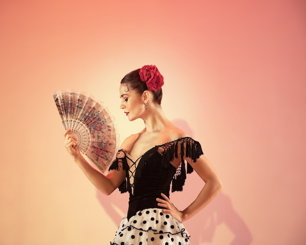 Ballerina di flamenco spagna donna zingara con rosa rossa e ventaglio spagnolo in posa e danza allo studio