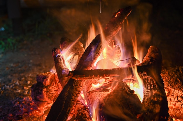 Fiamme da un falò di notte. stile di vita in viaggio avventuroso. voglia di vagabondaggio del concetto. vacanze attive per il fine settimana natura selvaggia all'aperto. il primo piano.