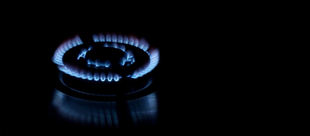Flames of gas stove over dark background, panoramic layout with space for text