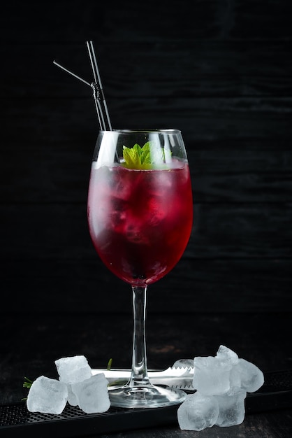 Flamingo Cocktail Liquor currants blackberries and mint Alcoholic cocktail in a glass On a wooden background Top view Free copy space