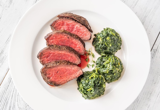 Flank steak with creamy spinach on the plate