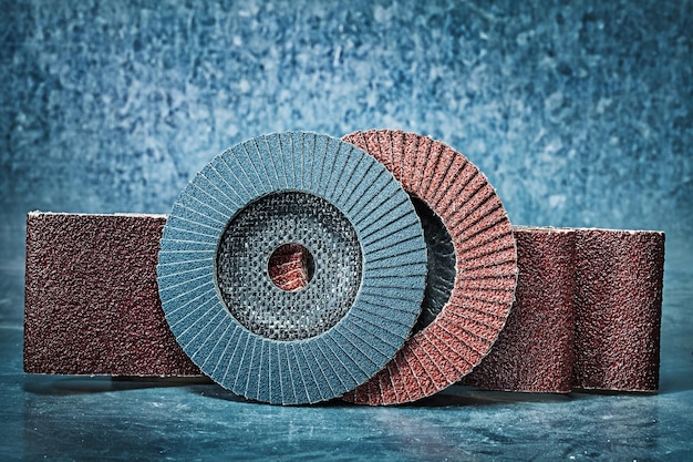 Flap discs and abrasive tapes on metalic background