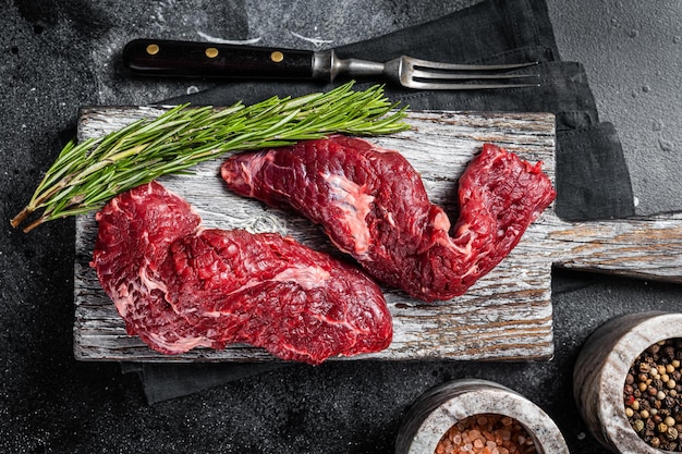 Flap steak flank raw cut and Machete skirt steak on wooden board Black background Top view