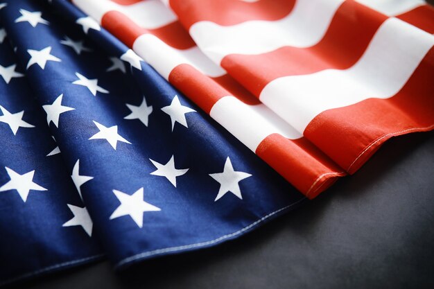 Размахивая флагом сша с волной. американский флаг на день памяти или 4 июля. крупный план американского флага на темном фоне