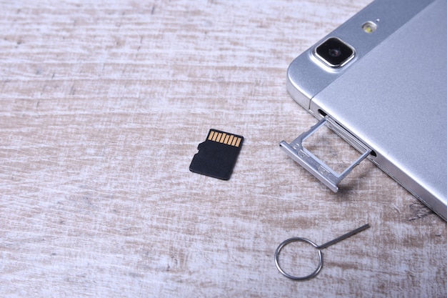 Flash memory data storage concept : A tray with a micro SD card. A memory card is used for storing digital information in portable electronic devices e.g mobile phone, tablets, etc