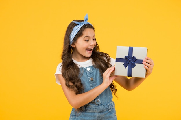 Acquisto vendita flash. bambino retrò estivo. la ragazza felice ha ricevuto una scatola regalo. sorpresa per lei. regalo di buon compleanno. felicità dell'infanzia. concetto di giorno di santo stefano. acquisti per bambini. ricompensa e premio.