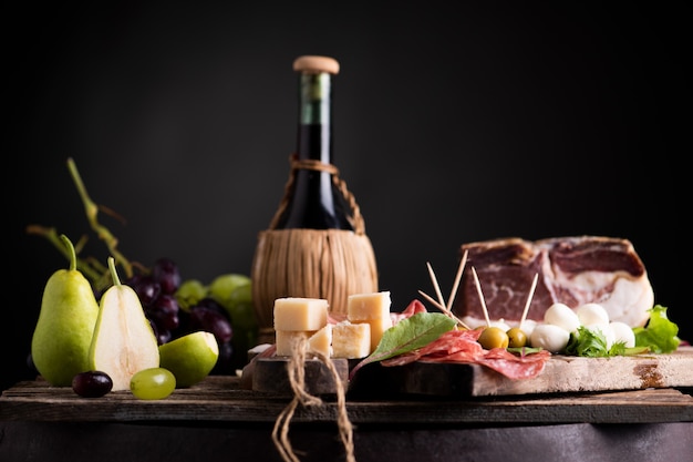 Фляжка вина на столе с традиционными деревенскими блюдами итальянской кухни. Свежий типичный итальянский образ жизни