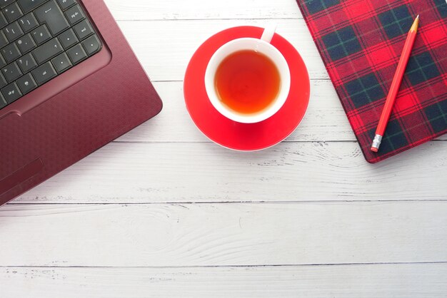 Flat composition of laptop and office stationary on black desk.