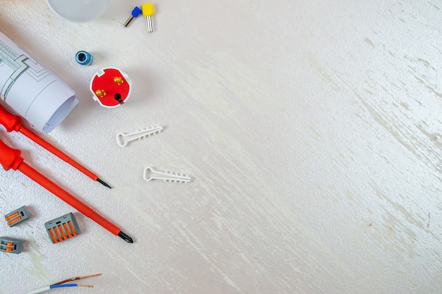 Flat composition with electrician tools on white background. Place for text. Selective focus.