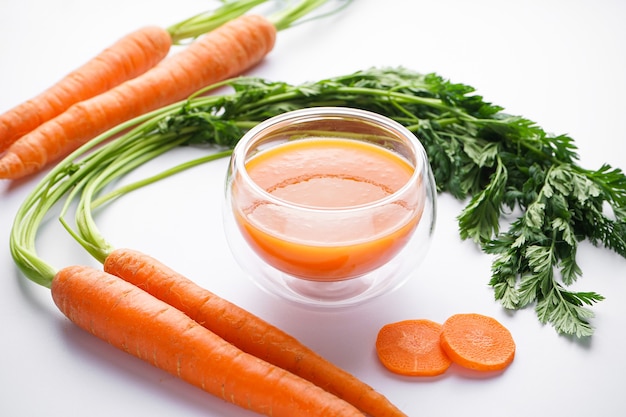 Flat composition with ripe fresh carrots and carrot juice isolated