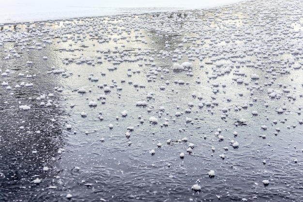 Flat ice on frozen pond, with small patches of crystalline snow.