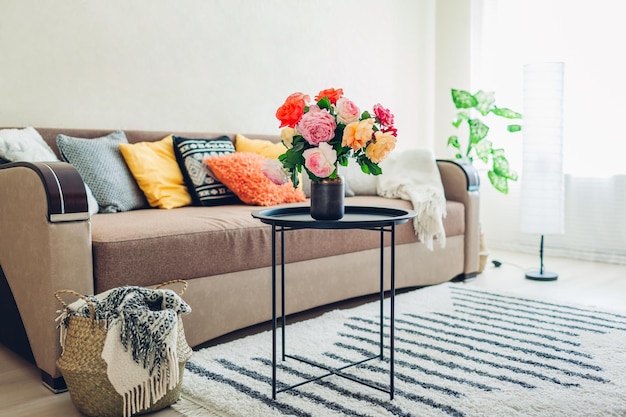 Flat interior of living room decorated with bouquet of peonies basket plants and carpet cat sleeping