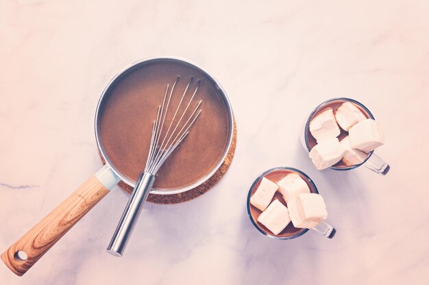 Flat lay. American hot chocolate topped with large marshmallow in glass cup.