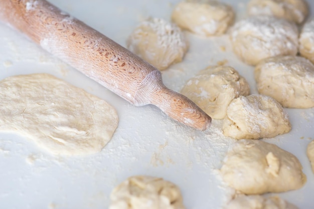 Flat lay angle view of a kitchen desk with flour dough and roller