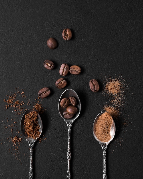 Flat lay arrangement of spoons filled with roasted coffee beans and powder