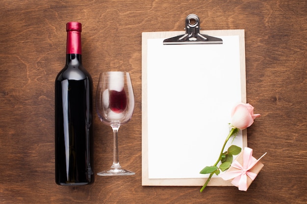 Flat lay arrangement with wine and clipboard