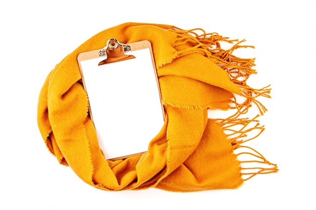 Flat lay autumn composition with notepad and a warm woolen scarf