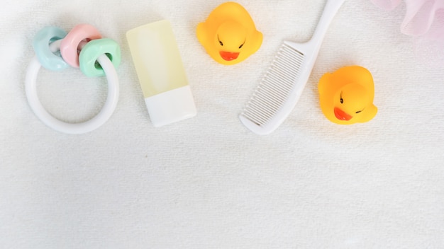 Flat lay baby bathroom stuff. shampoo, yellow duck, white hair brush. 