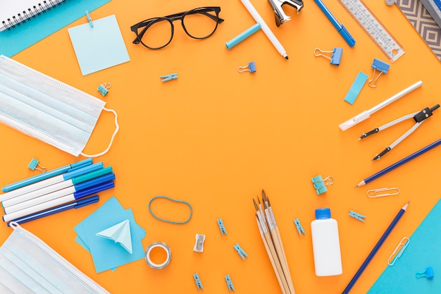 Photo flat lay of back to school supplies with glasses and hand sanitizer