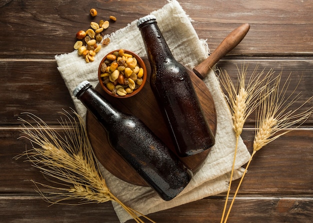 Flat lay of beer bottles with nuts and wheat