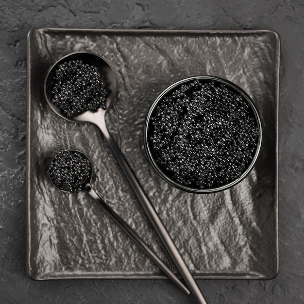 Photo flat lay of black caviar in bowl and spoons