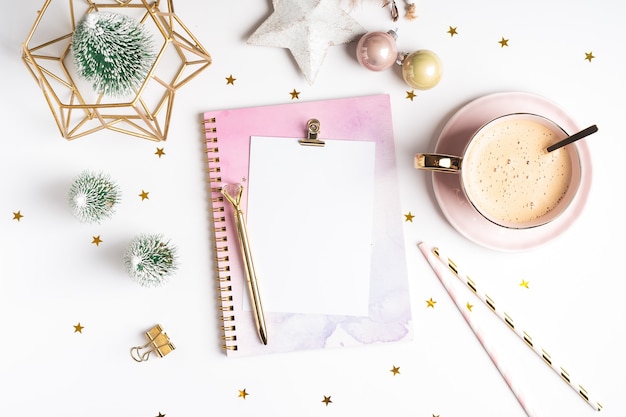 Flat lay of Blank notepad with cup of coffee and Christmas decoration.