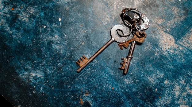 Flat lay of a blue table with several keys on it - real estate