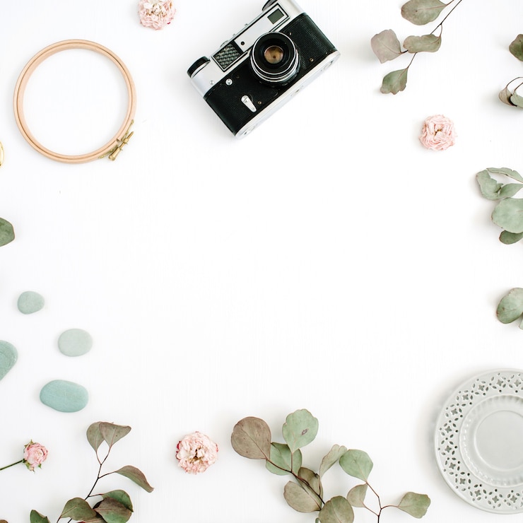 Photo flat lay border frame with retro camera, eucalyptus branches, plate on white