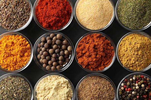 flat lay. bowls with different spices on black, close up