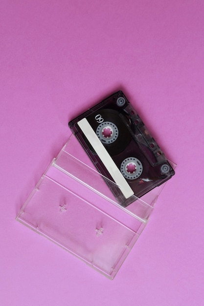 Flat lay cassette with transparent case on pink background