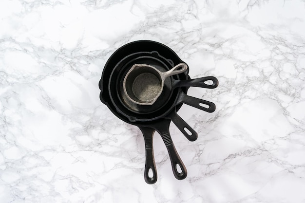 Flat lay. Cast iron frying pans on a marble background.