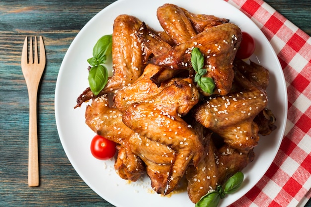 Flat lay chicken wings on plate with sesame seeds