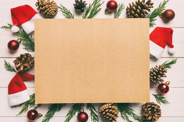 Плоская планировка рождественской композиции квадратная бумага пустые ветки сосны рождественские украшения на цветном фоне вид сверху копировать пространство для текста